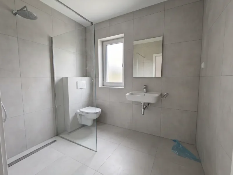 Jedna z ośmiu łazienek po remoncie — gres 60×60 i prysznic walk-in